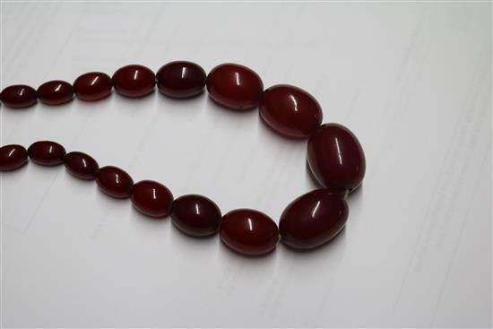 A single strand graduated simulated cherry amber oval bead necklace, gross weight 68 grams, 70cm.